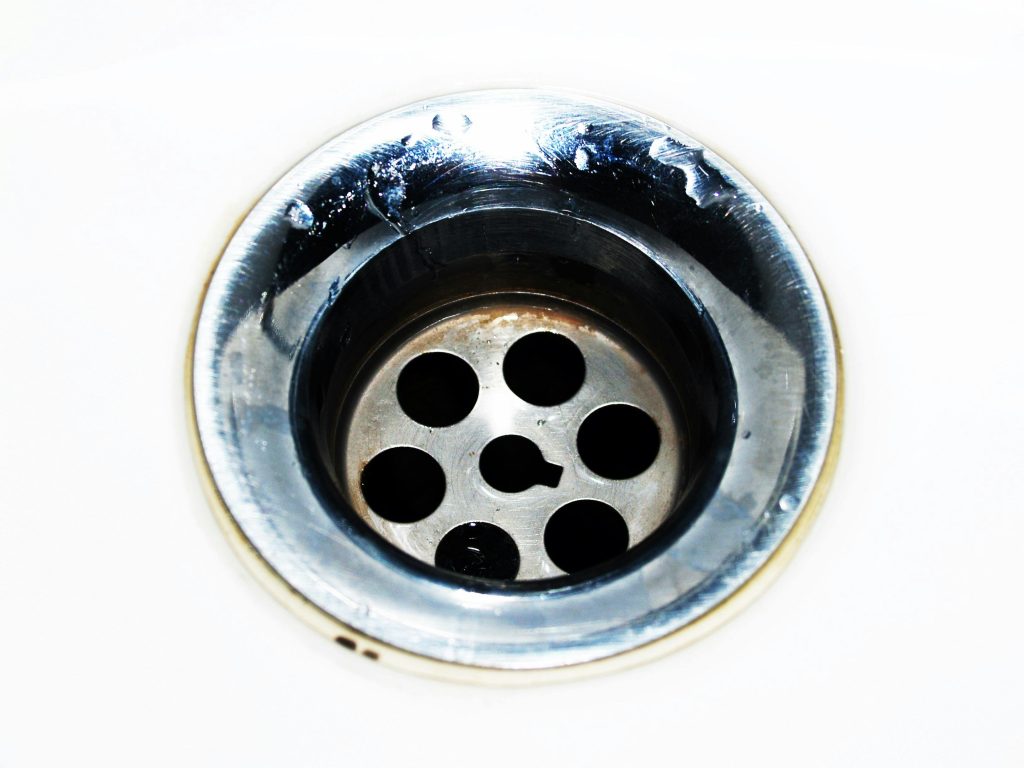 Recurring drain clogs causing slow drainage in home plumbing system