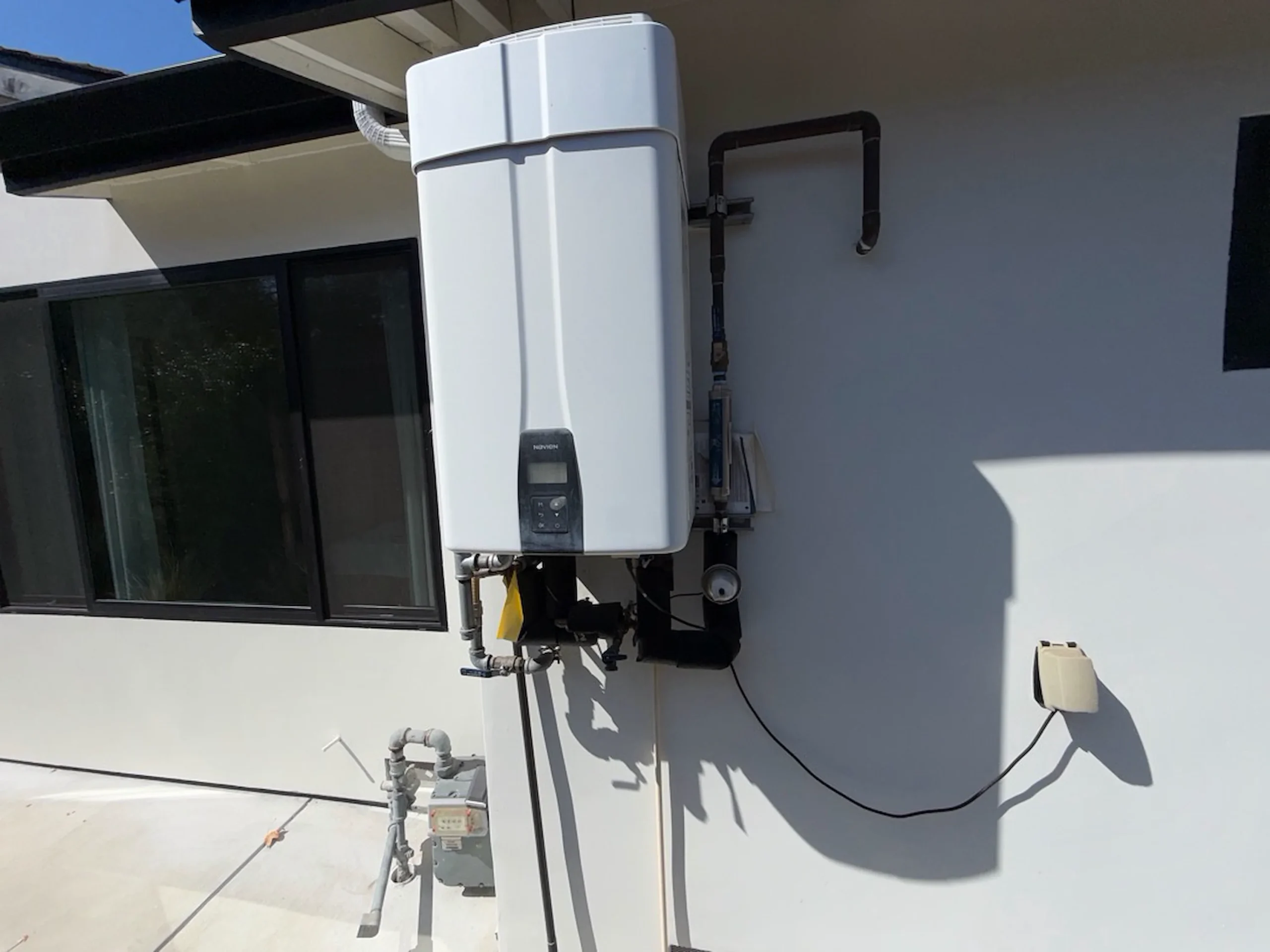 Tankless water heater mounted on the outside wall of a Los Gatos home